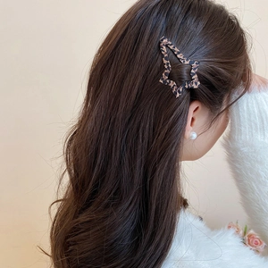 Fermaglio per capelli a stella leopardato indossato da una modella su capelli lunghi