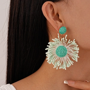 Bohemian mint green and white hand-woven flower tassel earrings worn by a model