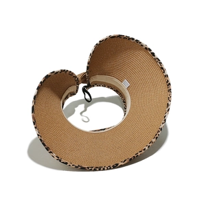 Folded view of a leopard print straw sun hat showing the rolled-up portable design