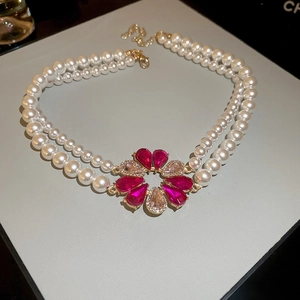 Macro shot of double-layer pearl necklace featuring a luxury floral crystal pendant