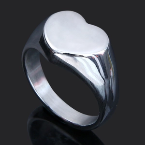 Macro shot of silver heart signet ring with polished exterior and brushed metal texture