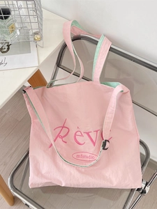 Pink canvas tote bag with Rêve embroidery on transparent chair in soft light