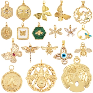 Collection of 16 gold insect and animal pendants with zircons on a white background