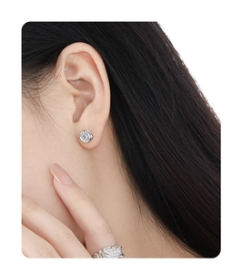 Detail showing irregular S925 sterling silver flower stud earring with shiny diamond on model