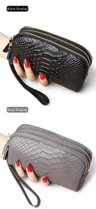 Detail view of double clutch bags in black and grey snakeskin leather with three zippers