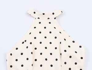 Détail du col licou beige à pois noirs sur un tissu à la texture délicate