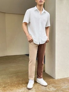 Detail of white waffle knit short sleeve shirt paired with beige and brown拼接 pants