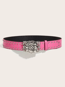 Close-up of pink punk style leather belt with silver floral buckle and round metal studs
