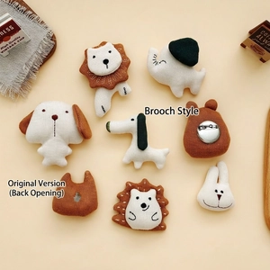 Handmade knitted animal brooches featuring lion, elephant and dog in warm tones