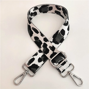 Close-up of leopard print bag strap with silver metal swivel hooks and adjustable buckle