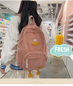 Detail of pink corduroy duck backpack with embroidered eyes and 3D beak feature