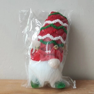 Détail d'un gnome de Noël en emballage transparent avec chapeau rayé et petite clochette