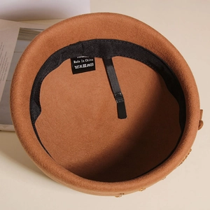 Detail of wool beret inner lining showing 100% wool label and adjustable sweatband
