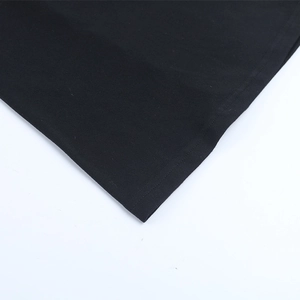 Detailed close-up showing the double-stitched hem and knit fabric texture of the black dress