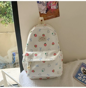 Close-up of white strawberry backpack with heart patterns and Fashion Mummy Bag label