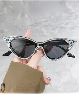 Detail of luxury cat-eye sunglasses with hand-set rhinestones and blue pear gemstones