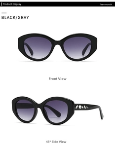 Detail of oval black sunglasses with crystal rhinestones on temples and gray lenses