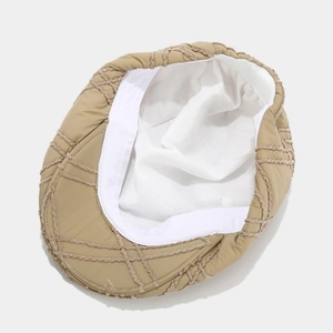 Detailed close-up of khaki newsboy hat featuring quilted fabric texture and soft inner lining