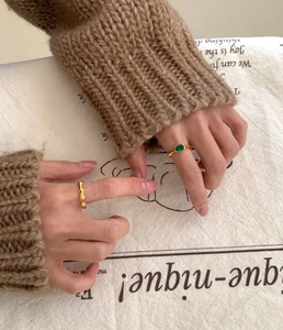Detail of 925 sterling silver bamboo texture ring with green emerald stone on a hand