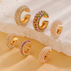 Detailed view of C-shaped gold-plated ear cuffs with pearls and colorful rhinestones