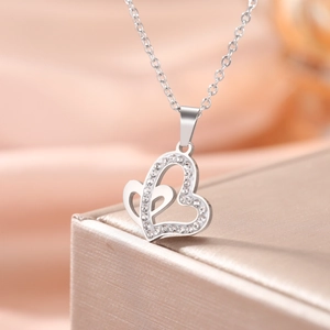 Close-up of silver interlocking heart necklace with crystals on velvet jewelry box