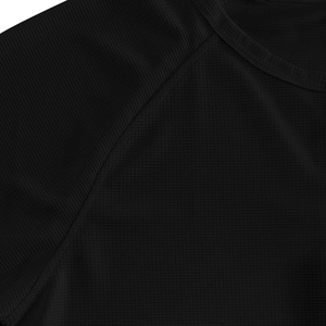 Macro shot of black waffle knit fabric texture and shoulder stitching on a men's henley shirt