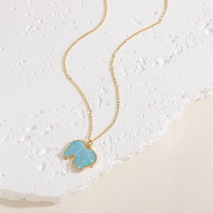 Detail view of gold elephant pendant with blue shell inlay on minimalist cable chain