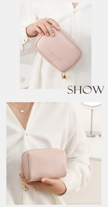 Close-up of light pink PU leather makeup bag with gold zipper charm and printed text
