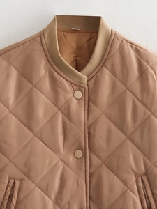 Close-up of camel quilted jacket featuring diamond stitching and ribbed stand collar detail
