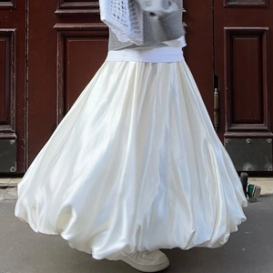 Detail of white satin high-waisted midi skirt with a voluminous puff A-line silhouette