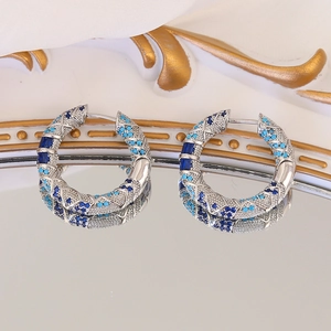 Vintage round hoop earrings with blue zircon in a wave design on white silk background