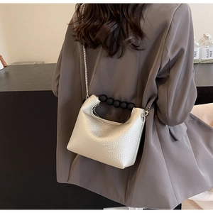 Detail of silver lychee texture bag with black bead handle and silver chain strap