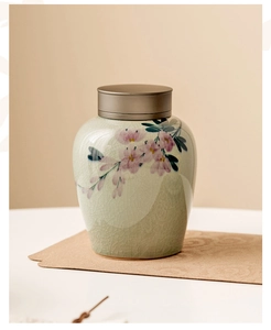 Detail of hand-painted floral pattern on green ice-cracked glaze ceramic tea canister