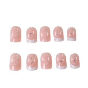 Short French tip press-on nails in nude pink with white maple leaf designs and glitter