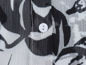 Close-up of chiffon blouse showing retro print texture and white button detail