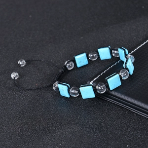 Detailansicht eines verstellbaren geflochtenen Armbands mit blauen Steinen und Kristallen