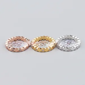 Detail view of hexagonal geometric rings in rose gold, gold, and silver with zircon insets