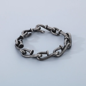 Macro detail of industrial vintage style square nail link bracelet in oxidized steel finish