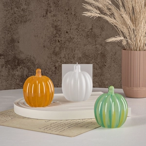 Macro shot of 3D pumpkin silicone molds and resin ornaments on a tiered white display