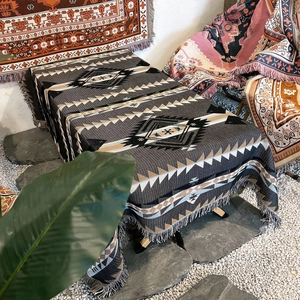 Detail of bohemian woven camping blanket with geometric patterns and fringe edges