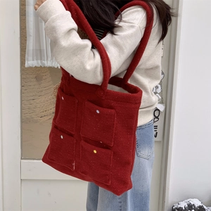 Side view of red felt tote bag with four colorful polka dot pockets in outdoor setting