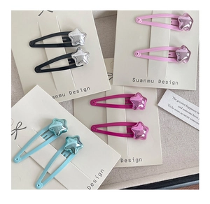 Close-up of metallic star hair clips in black, pink, rose red and blue colors
