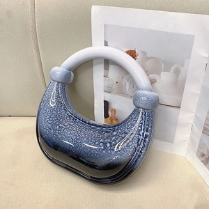 Close-up of blue and white crescent acrylic clutch showing artistic textured glaze finish