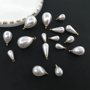 Water drop pearl pendants with gold rings on black background for jewelry making