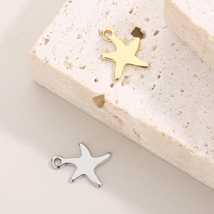 Detailed view of gold and silver starfish pendants on textured stone for DIY jewelry