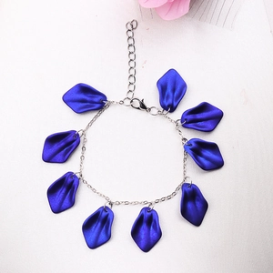 Bohemian style bracelet with blue petal pendants and silver chain on white background