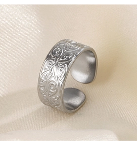 Detailed side view of silver engraved open ring with eye patterns on champagne silk