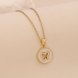 Detail der 18K vergoldeten Halskette mit weißem Perlmutt-Anhänger und Diamant-Schmetterling