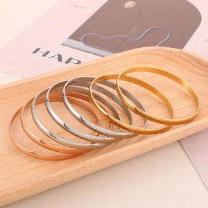 Stack of gold, silver, and rose gold polished stainless steel thin bangle bracelets