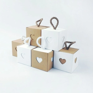 Detail of square kraft paper gift bags with heart cut-out and rustic hemp rope handles